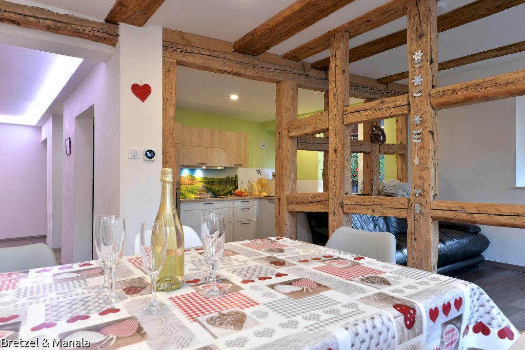 La salle à manger, on aperçoit le hall, la cuisine et le petit salon.